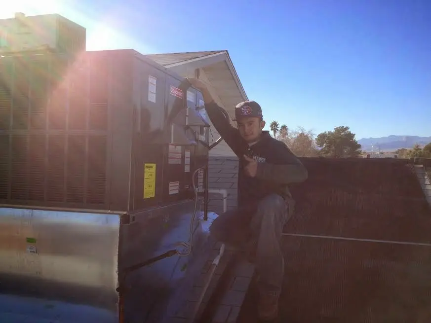 HVAC technician performing Air Duct Repair on a rooftop unit in Harrisville